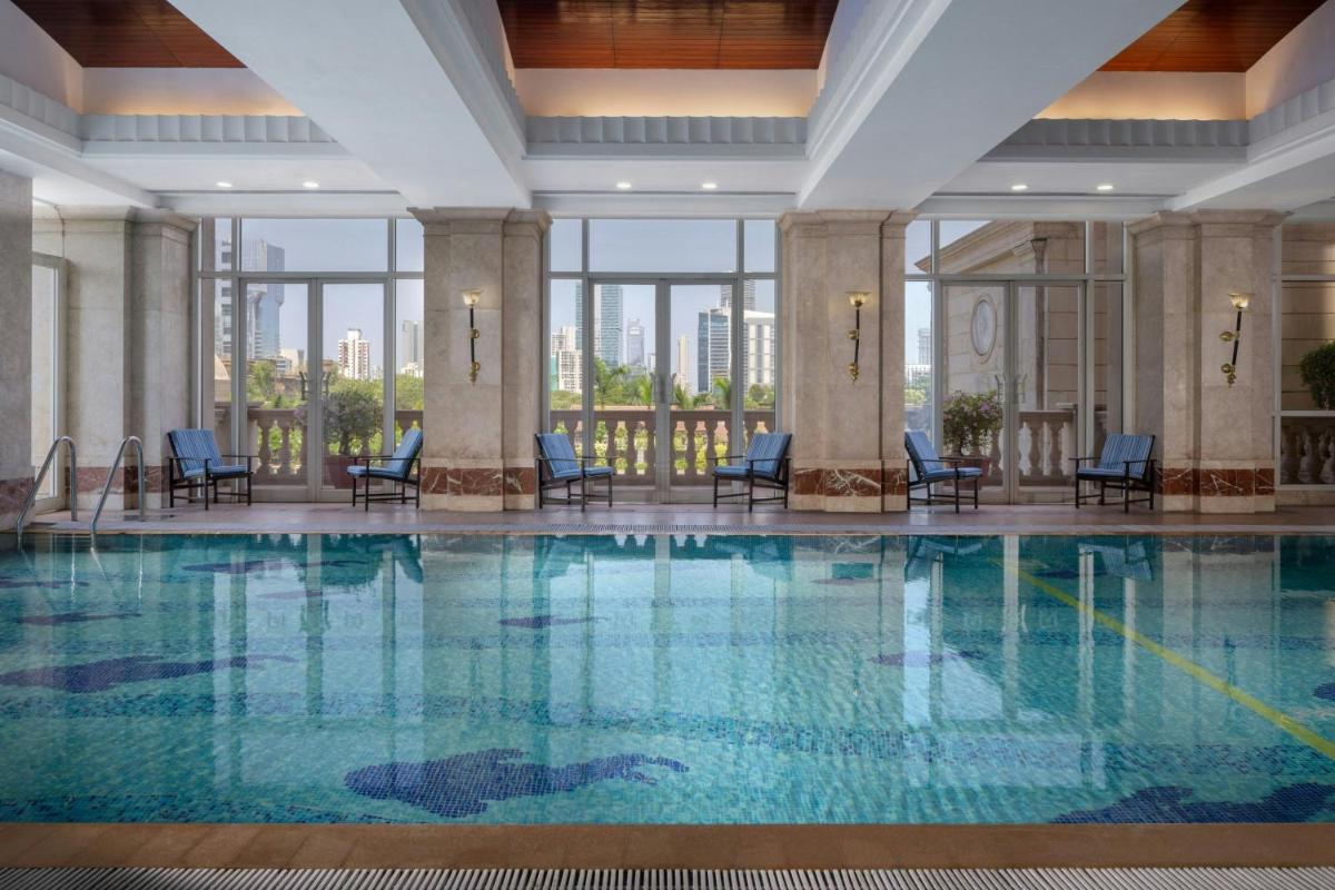 a pool in a hotel with chairs and windows at ITC Grand Central, a Luxury Collection Hotel, Mumbai in Mumbai a pool in a hotel with chairs and windows at ITC Grand Central, a Luxury Collection Hotel, Mumbai in Mumbai