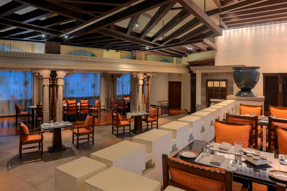 a restaurant with tables and chairs in a room at ITC Grand Central, a Luxury Collection Hotel, Mumbai in Mumbai