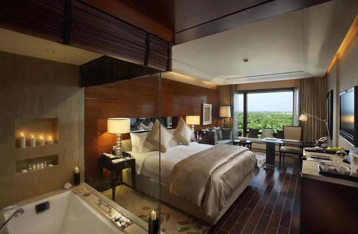 a bedroom with a bed and a tub in a room at The Leela Ambience Gurugram Hotel & Residences - The Luxury Urban Sanctuary in Gurgaon