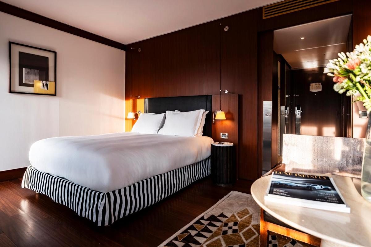 une chambre d'hôtel avec un grand lit et un bureau dans l'établissement Grand Hôtel Champs-Elysées, à Paris