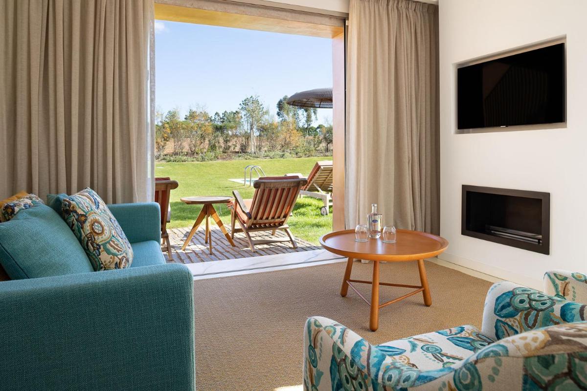 uma sala de estar com um sofá, cadeiras e uma mesa em Praia do Canal Nature Retreat - Small Luxury Hotels of the World em Aljezur