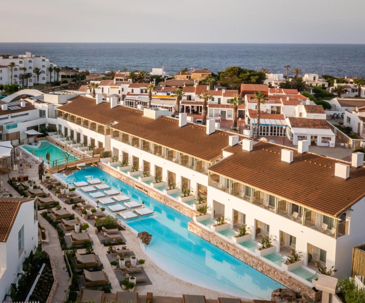 una vista aérea del hotel y el océano en Lago Resort Menorca - Suites del Lago Adults Only, en Cala'n Bosch