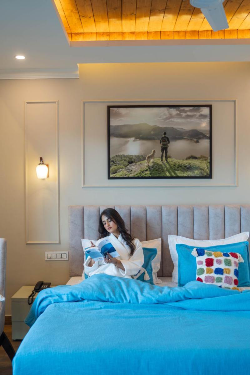 a woman sitting on top of a bed at Perfectstayz Premium Westend at Mall Road in Mussoorie