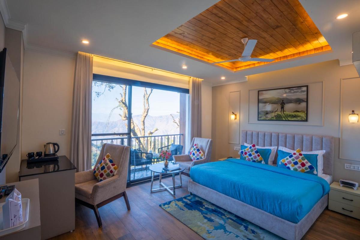 a bedroom with a blue bed and a balcony at Perfectstayz Premium Westend at Mall Road in Mussoorie