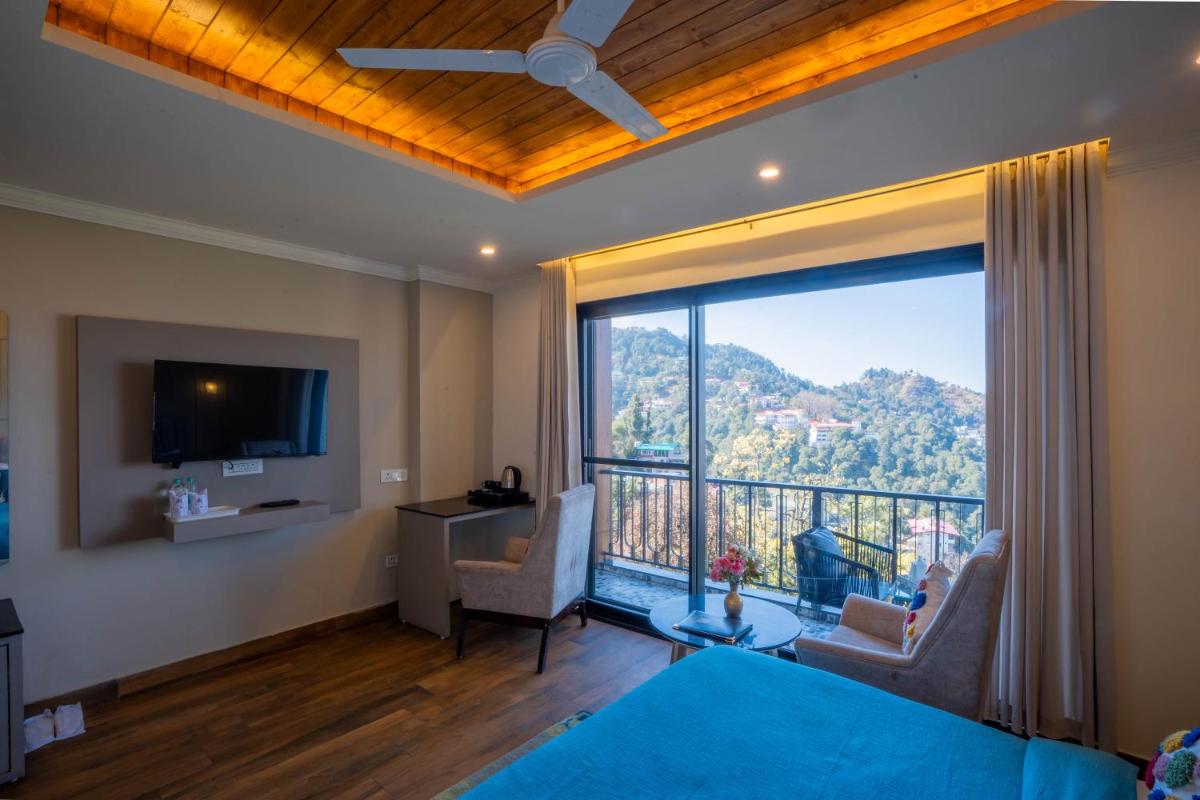 a living room with a large window with a view at Perfectstayz Premium Westend at Mall Road in Mussoorie