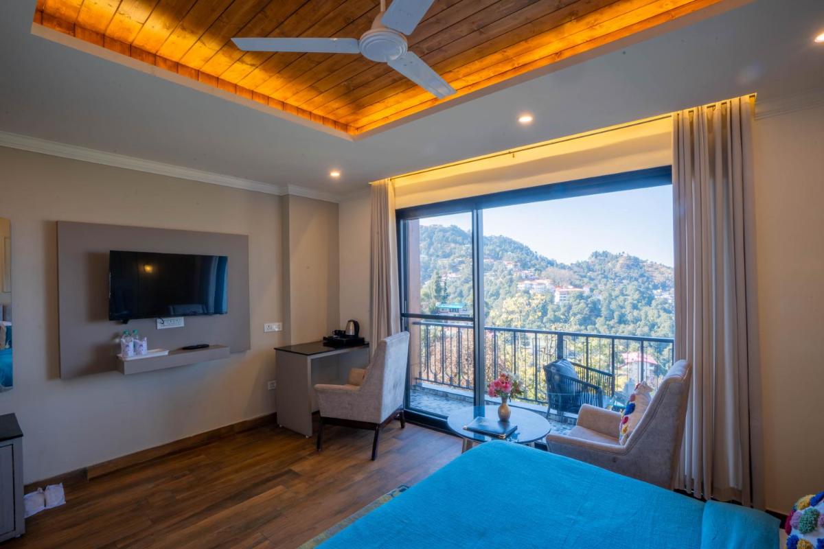 a bedroom with a large window with a view at Perfectstayz Premium Westend at Mall Road in Mussoorie