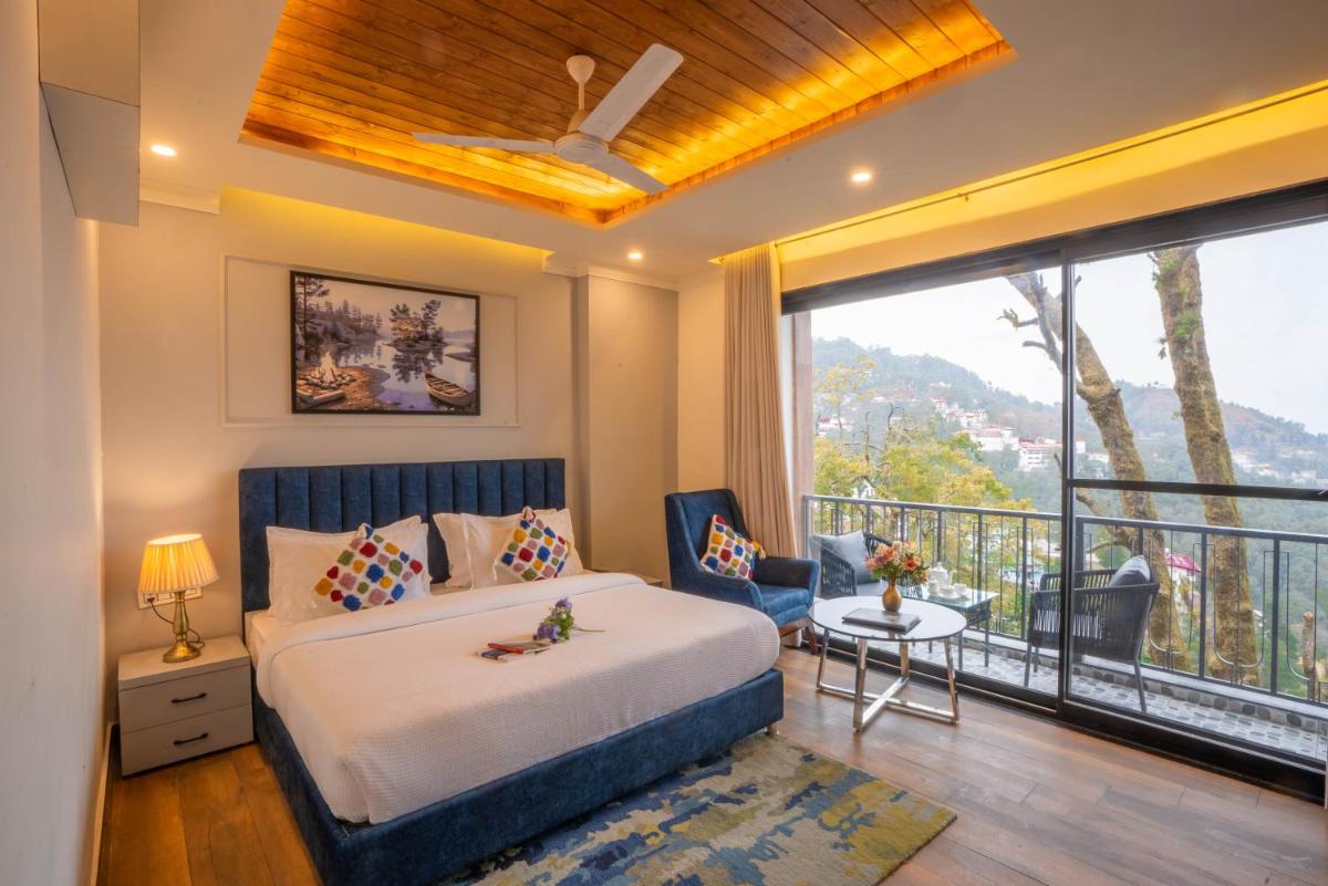 a bedroom with a bed and a balcony at Perfectstayz Premium Westend at Mall Road in Mussoorie