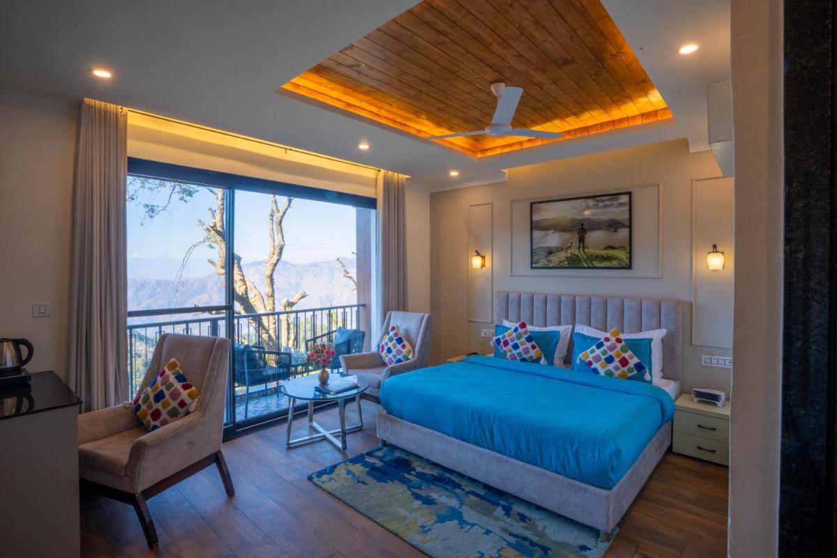 a bedroom with a bed and a balcony at Perfectstayz Premium Westend at Mall Road in Mussoorie