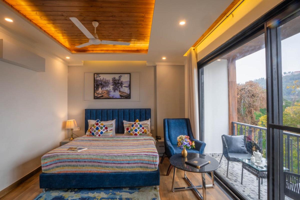 a bedroom with a bed and two chairs at Perfectstayz Premium Westend at Mall Road in Mussoorie