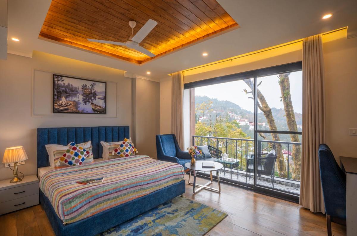 a bedroom with a bed and a balcony at Perfectstayz Premium Westend at Mall Road in Mussoorie