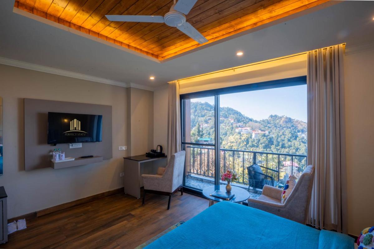 a living room with a large window with a view at Perfectstayz Premium Westend at Mall Road in Mussoorie