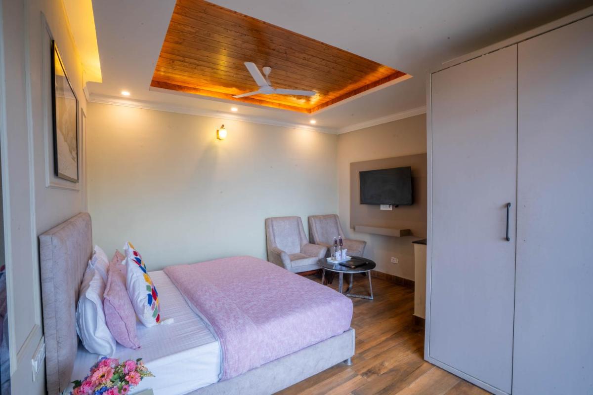 a bedroom with a bed and a ceiling at Perfectstayz Premium Westend at Mall Road in Mussoorie