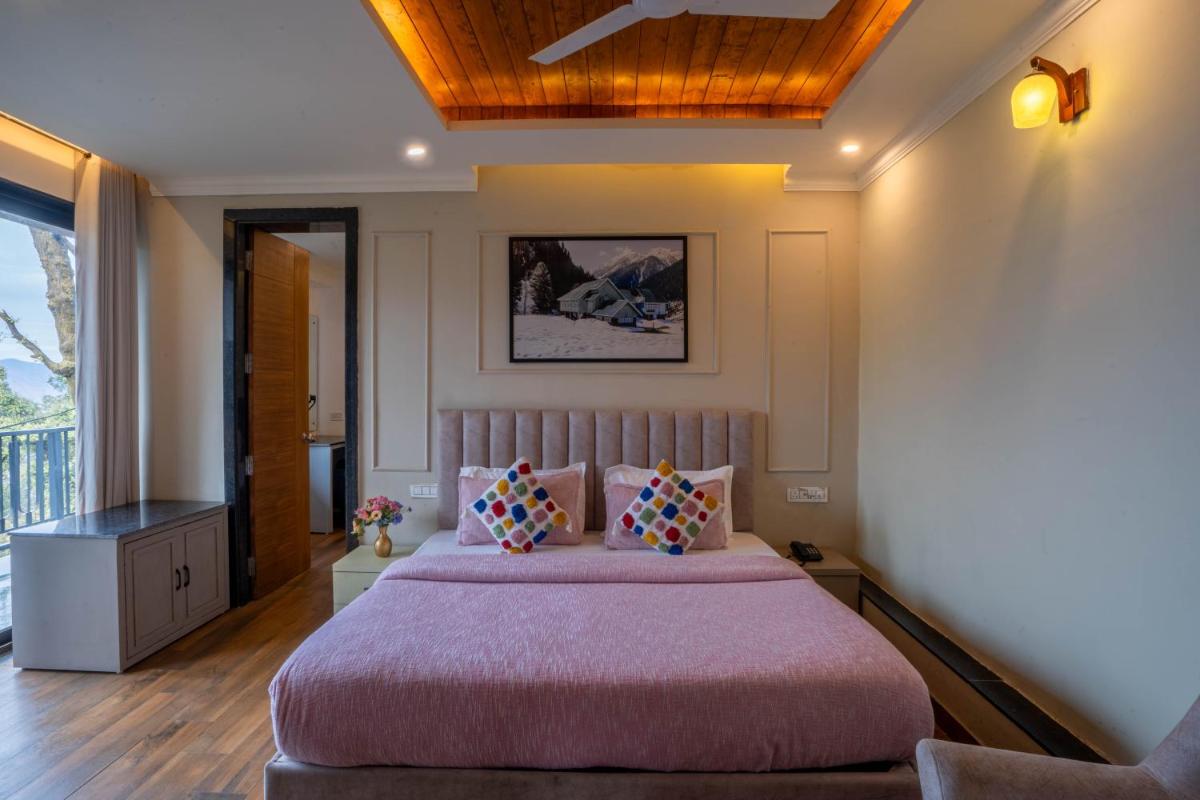 a bedroom with a large bed with pink sheets and pillows at Perfectstayz Premium Westend at Mall Road in Mussoorie
