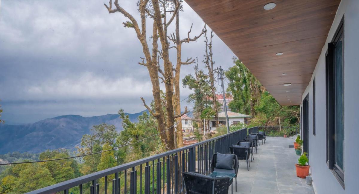 a balcony with chairs and a view of mountains at Perfectstayz Premium Westend at Mall Road in Mussoorie