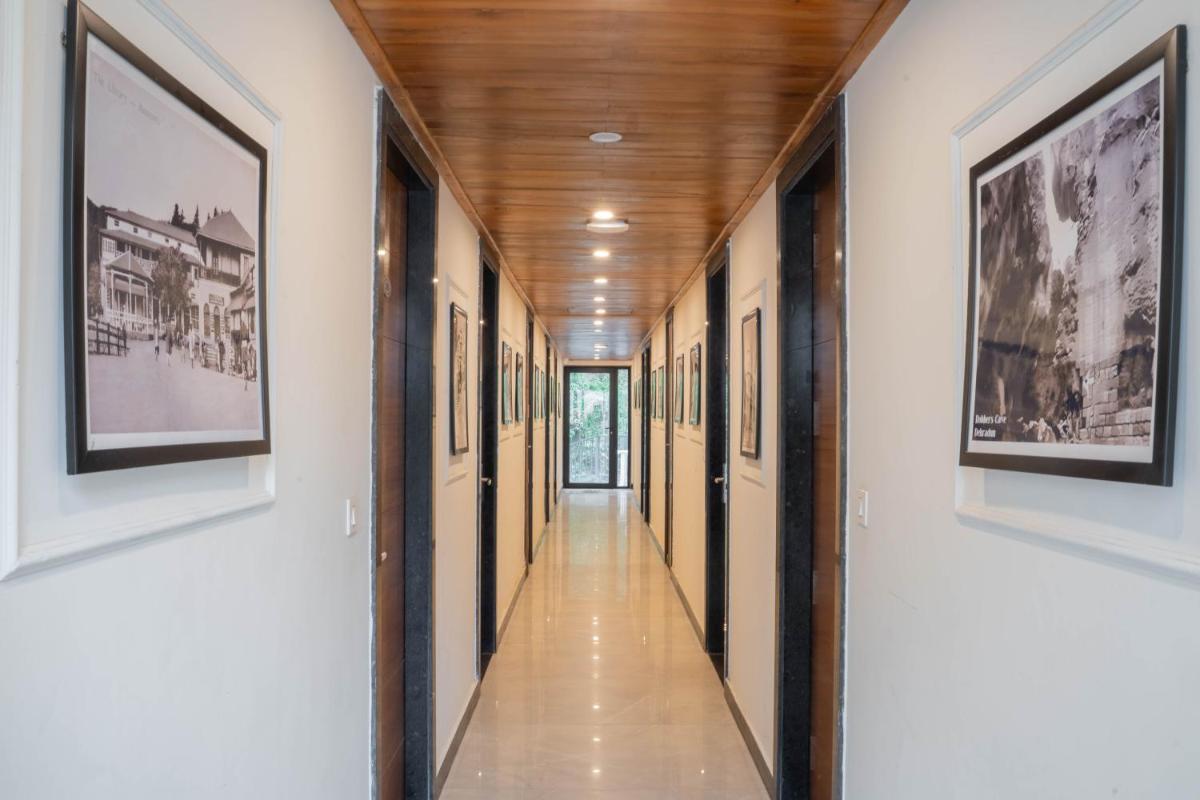 a hallway with framed photographs on the walls of a building at Perfectstayz Premium Westend at Mall Road in Mussoorie
