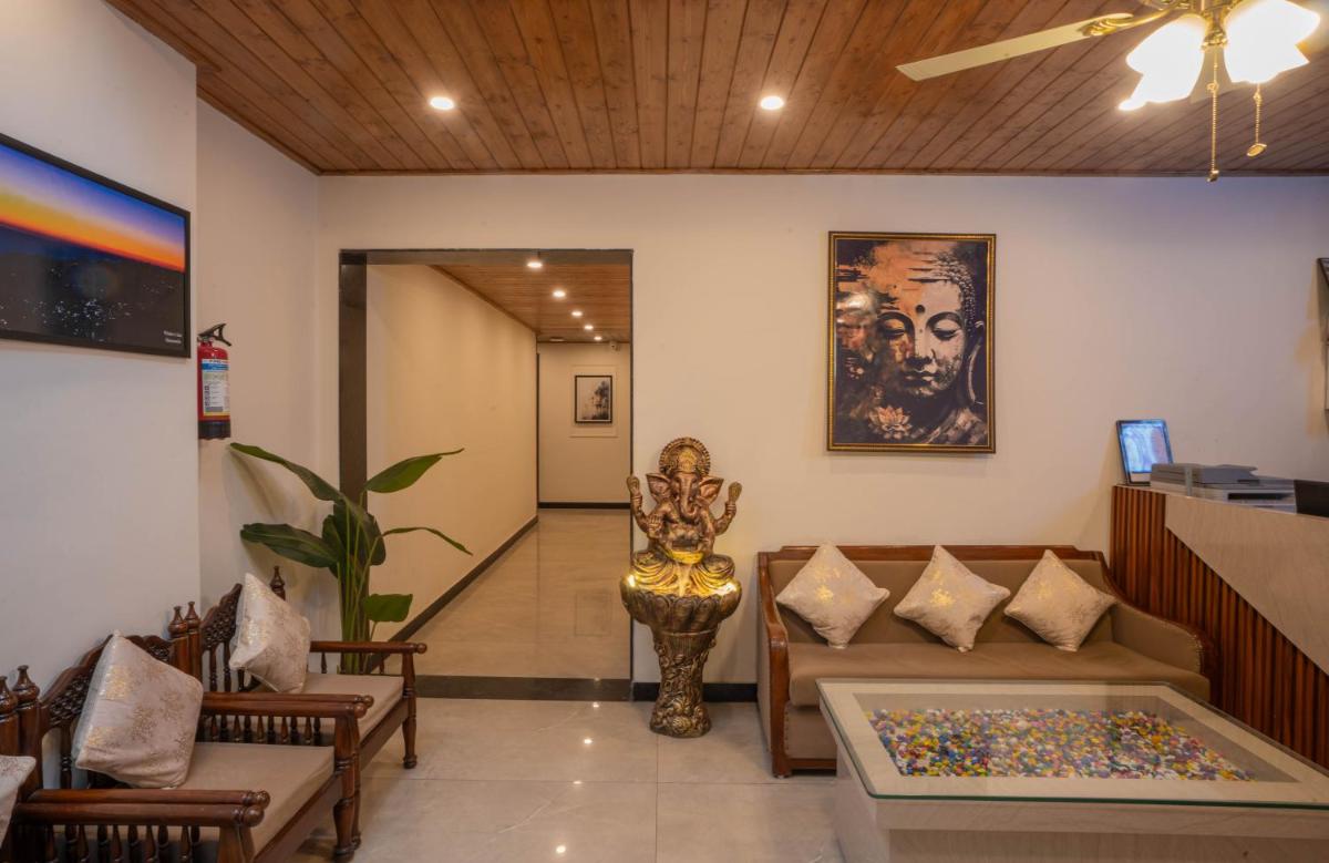a lobby with a couch and chairs and a painting at Perfectstayz Premium Westend at Mall Road in Mussoorie
