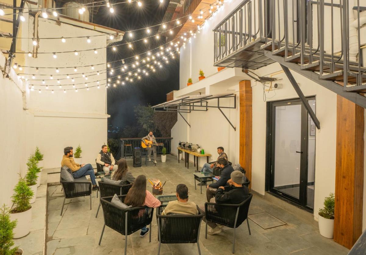 a group of people sitting in chairs in a patio with lights at Perfectstayz Premium Westend at Mall Road in Mussoorie