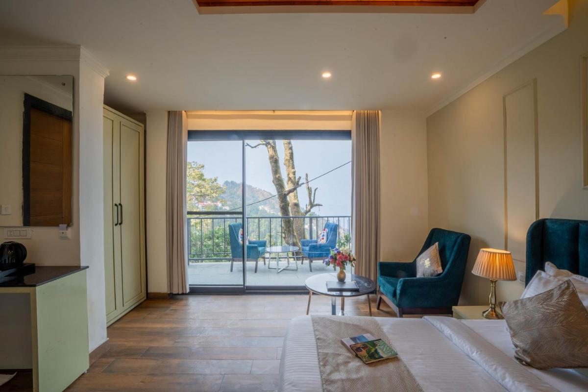 a bedroom with a bed and a view of a balcony at Perfectstayz Premium Westend at Mall Road in Mussoorie