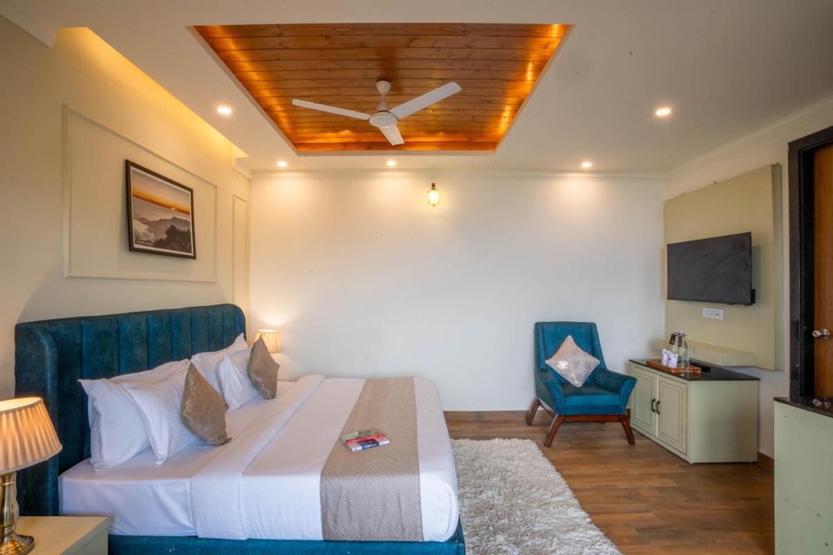 a bedroom with a bed with a ceiling fan at Perfectstayz Premium Westend at Mall Road in Mussoorie