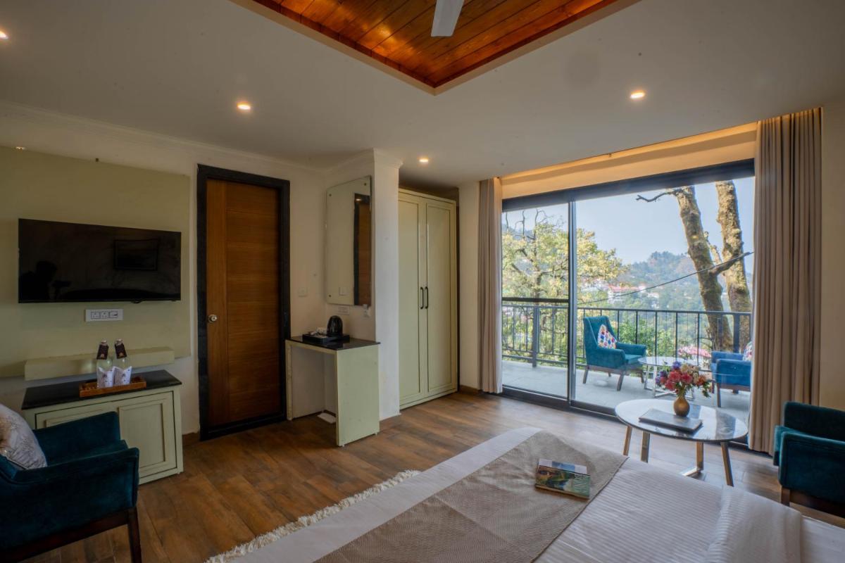 a living room with a view of a balcony at Perfectstayz Premium Westend at Mall Road in Mussoorie