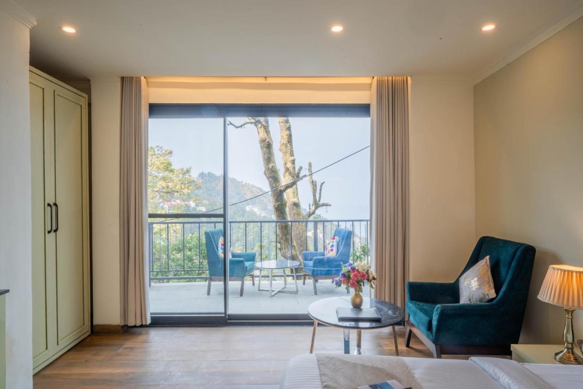 a living room with a view of a balcony at Perfectstayz Premium Westend at Mall Road in Mussoorie