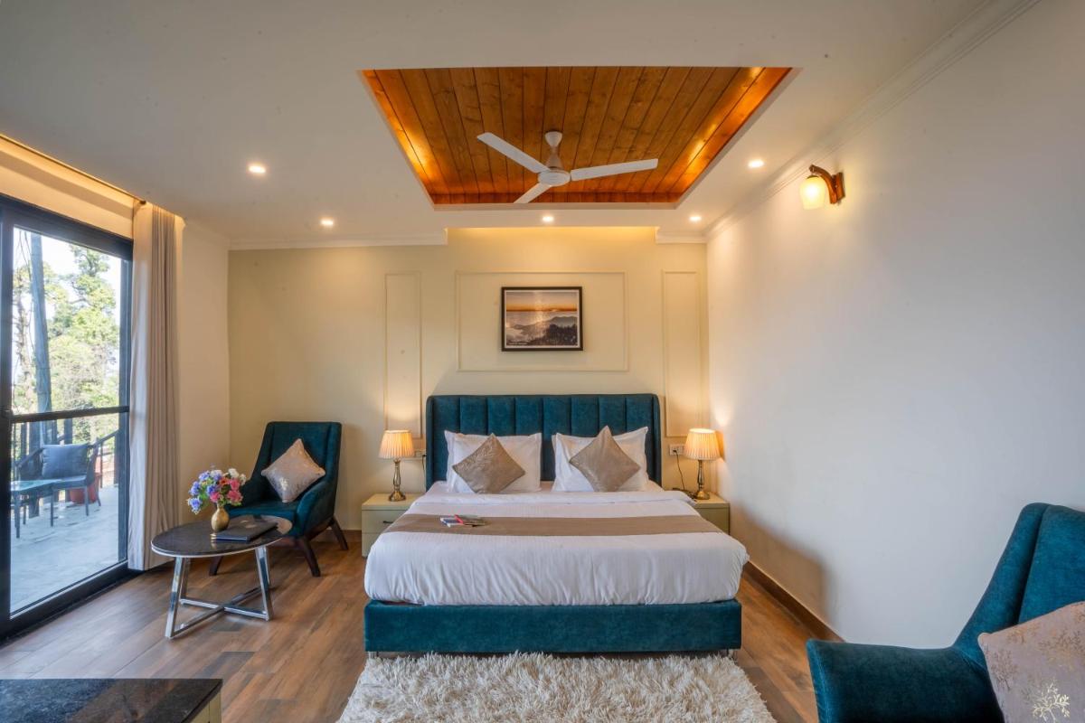 a hotel room with a bed and two chairs at Perfectstayz Premium Westend at Mall Road in Mussoorie