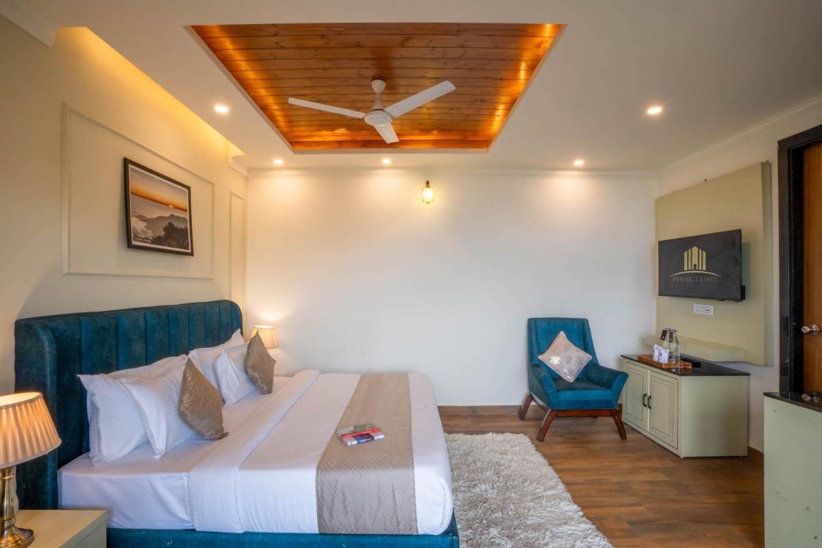 a bedroom with a bed and a ceiling fan at Perfectstayz Premium Westend at Mall Road in Mussoorie