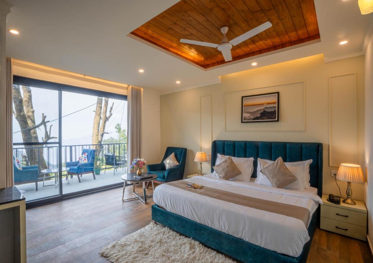 a bedroom with a large bed and a balcony at Perfectstayz Premium Westend at Mall Road in Mussoorie