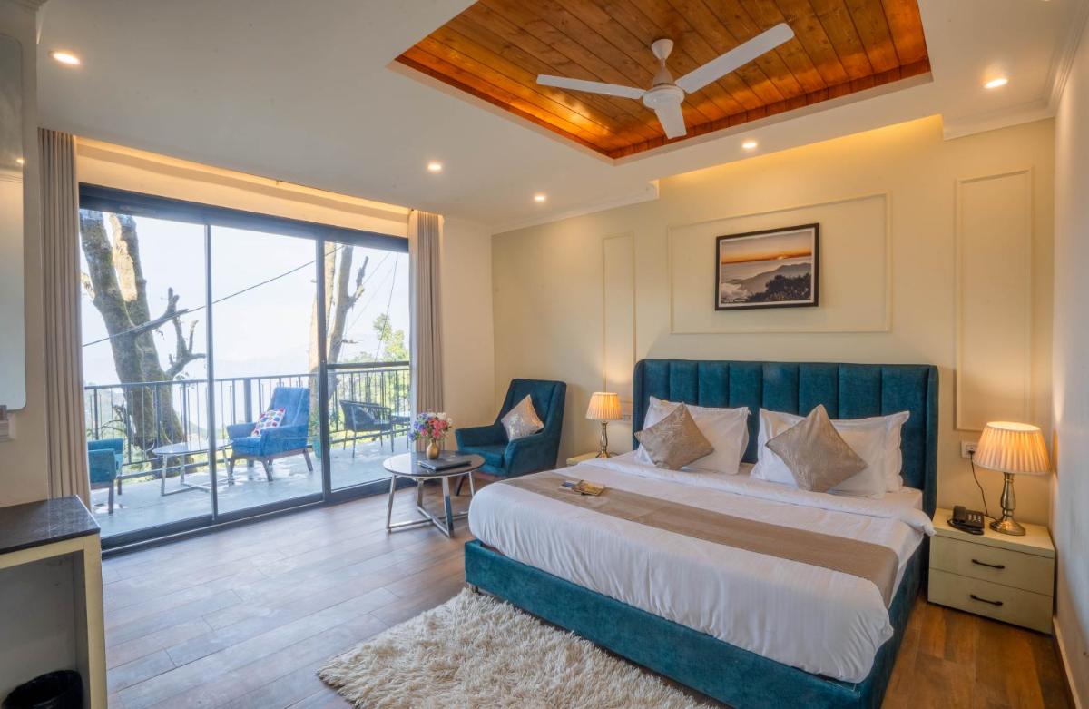 a bedroom with a large bed and a balcony at Perfectstayz Premium Westend at Mall Road in Mussoorie