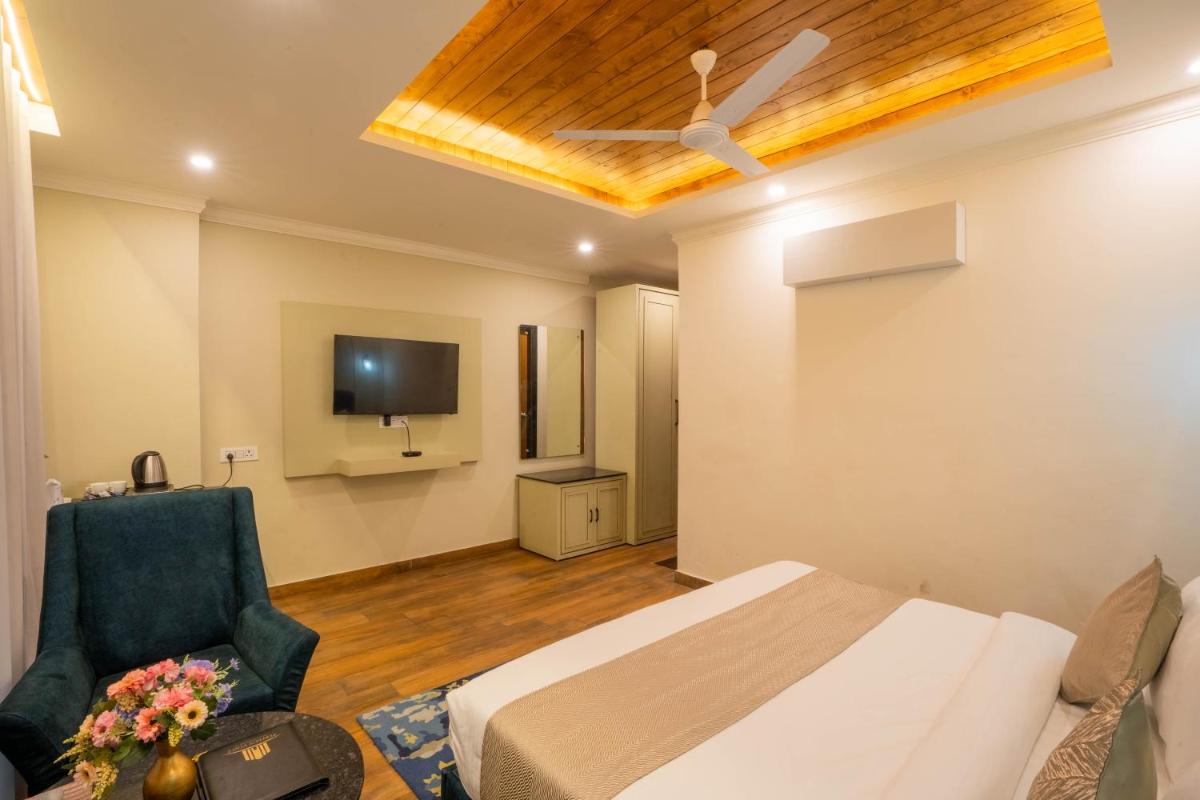 a hotel room with a bed and a tv at Perfectstayz Premium Westend at Mall Road in Mussoorie