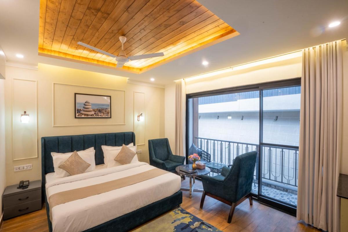 a hotel room with a bed and a balcony at Perfectstayz Premium Westend at Mall Road in Mussoorie