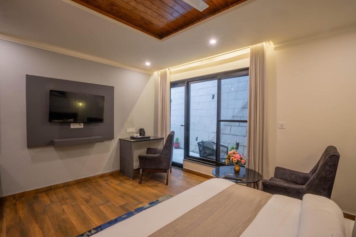a bedroom with a bed and a television and a desk at Perfectstayz Premium Westend at Mall Road in Mussoorie