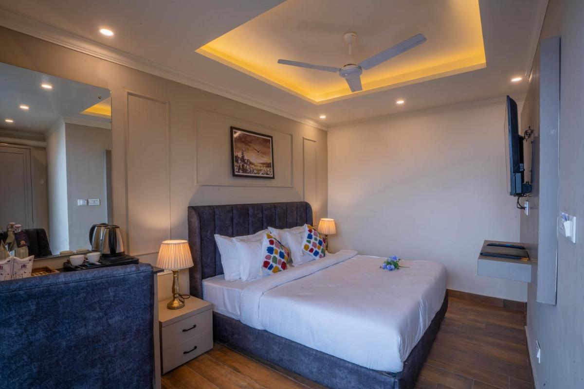 a bedroom with a large bed with a ceiling at Perfectstayz Premium Westend at Mall Road in Mussoorie