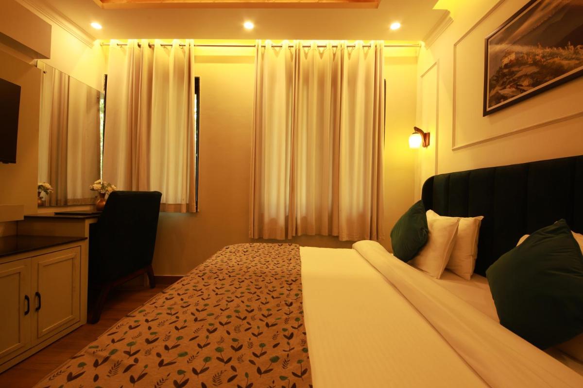 a hotel room with a large bed and a mirror at Perfectstayz Premium Westend at Mall Road in Mussoorie