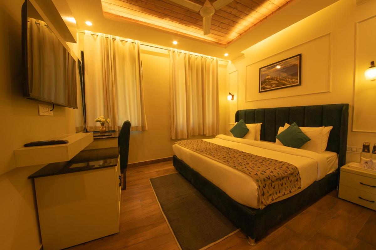 a hotel room with a bed and a television at Perfectstayz Premium Westend at Mall Road in Mussoorie