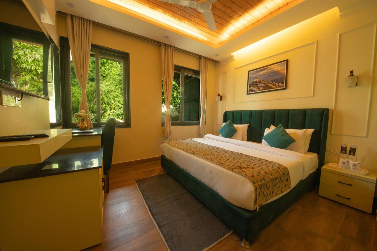 a hotel room with a bed and a desk at Perfectstayz Premium Westend at Mall Road in Mussoorie