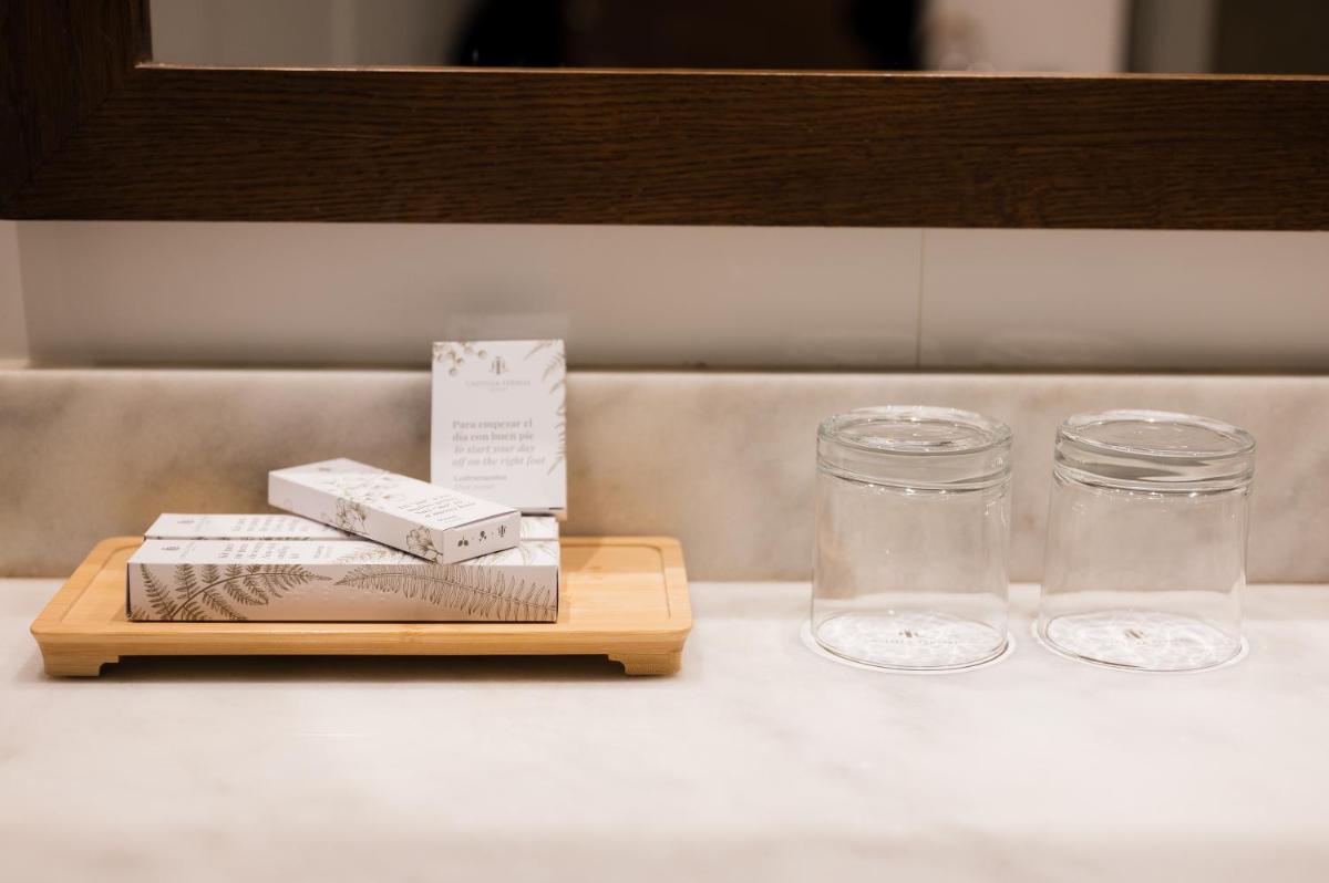 Una mesa con dos vasos y libros en una bandeja. en Castilla Termal Solares, en Solares