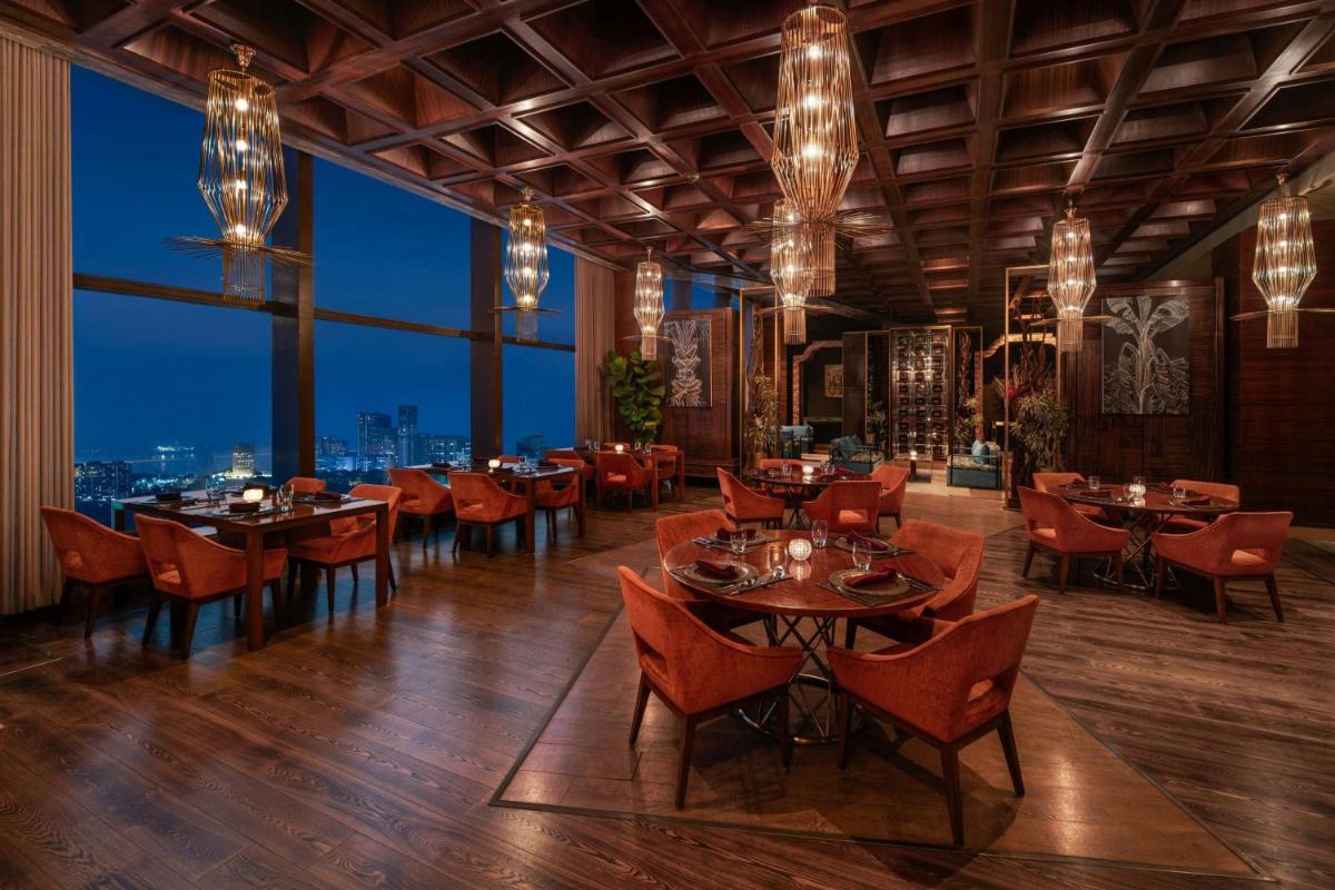 a restaurant with tables and chairs and a view of the city at The St. Regis Mumbai in Mumbai