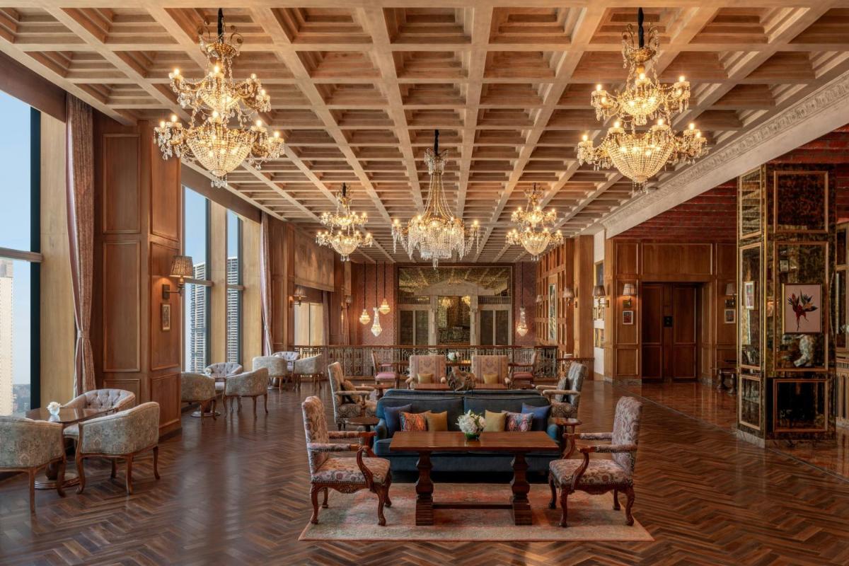 a large lobby with a blue couch and chairs at The St. Regis Mumbai in Mumbai