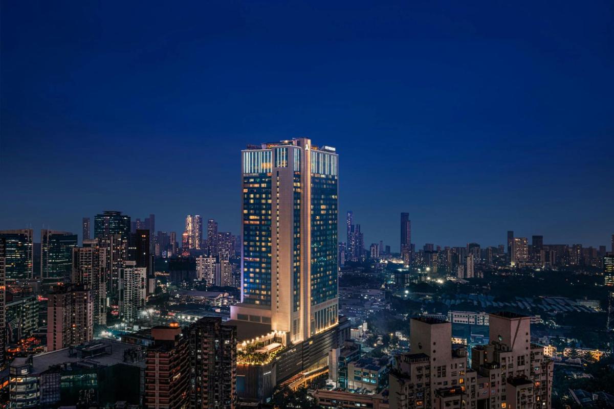 a lit up skyscraper in a city at night at The St. Regis Mumbai in Mumbai a lit up skyscraper in a city at night at The St. Regis Mumbai in Mumbai