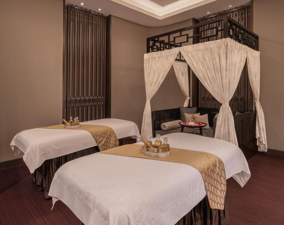 a room with two beds with white sheets at The St. Regis Mumbai in Mumbai