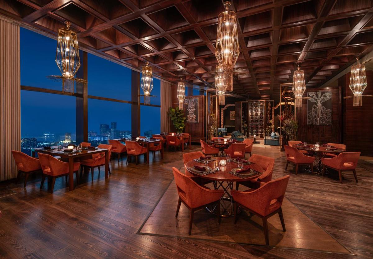 a restaurant with tables and chairs and a view of the city at The St. Regis Mumbai in Mumbai