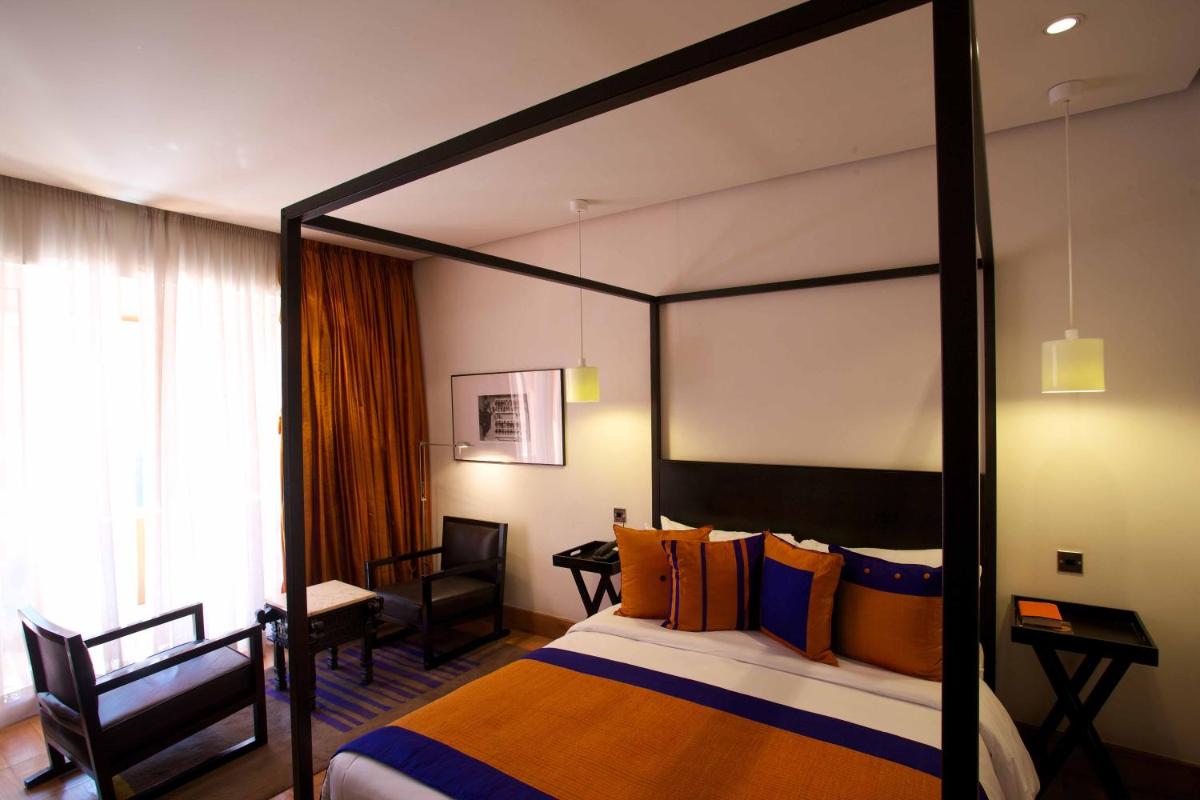 a hotel room with a canopy bed and a desk at The Park Bangalore, MG Road in Bengaluru a hotel room with a canopy bed and a desk at The Park Bangalore, MG Road in Bengaluru