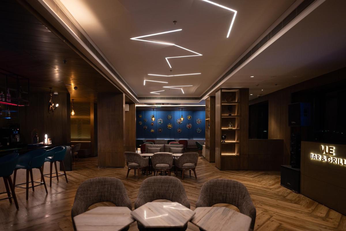 a lobby with chairs and a bar in a room at Courtyard by Marriott Amritsar in Amritsar