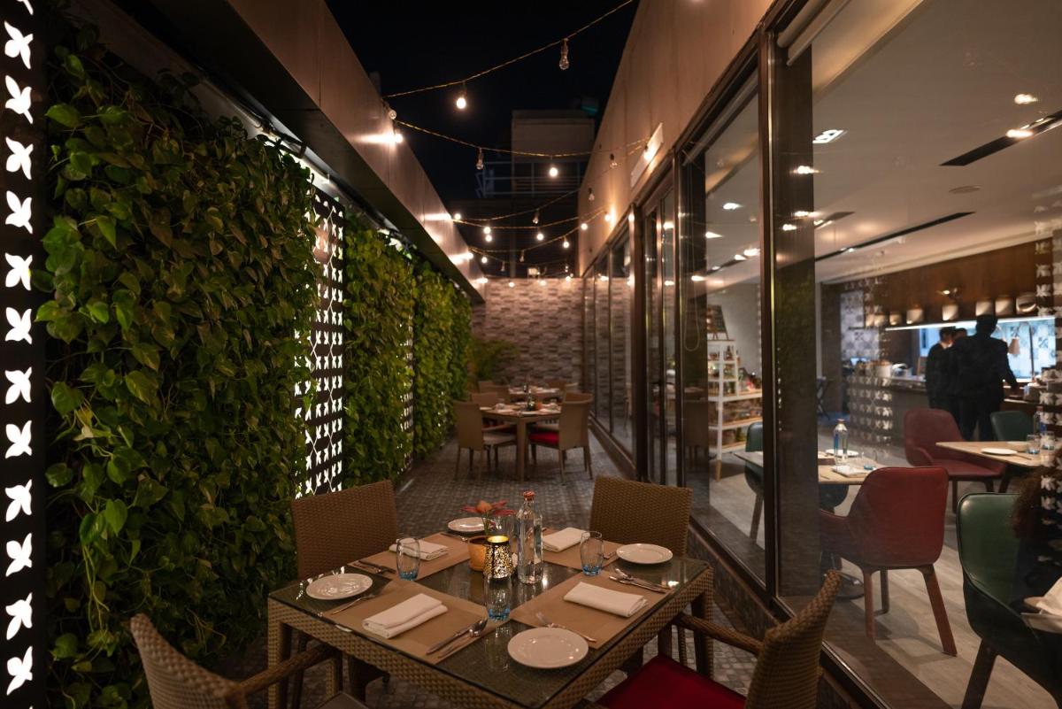 a restaurant with tables and chairs and a green wall at Courtyard by Marriott Amritsar in Amritsar