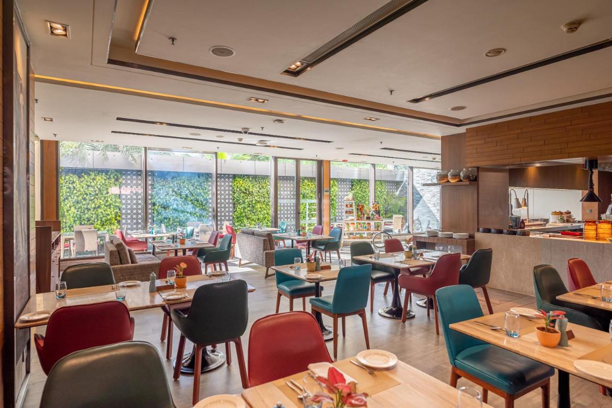 a restaurant with tables and chairs and windows at Courtyard by Marriott Amritsar in Amritsar