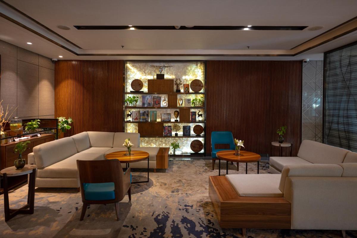 a living room with a couch and tables and chairs at Courtyard by Marriott Amritsar in Amritsar