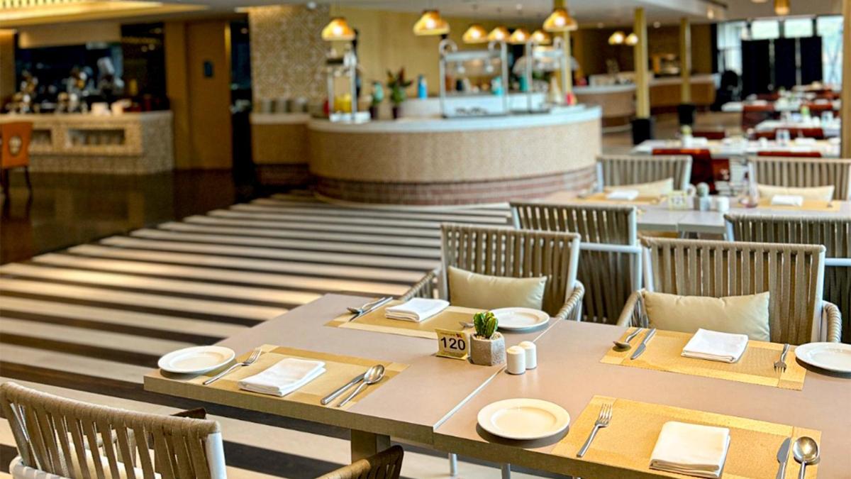 a dining room with a table and chairs in a restaurant at Crowne Plaza Kochi by IHG in Cochin