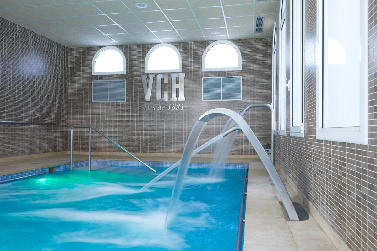 Una piscina con un tobogán de agua en una habitación. en 1881 Hotel Balneario Vichy Catalan, en Caldes de Malavella