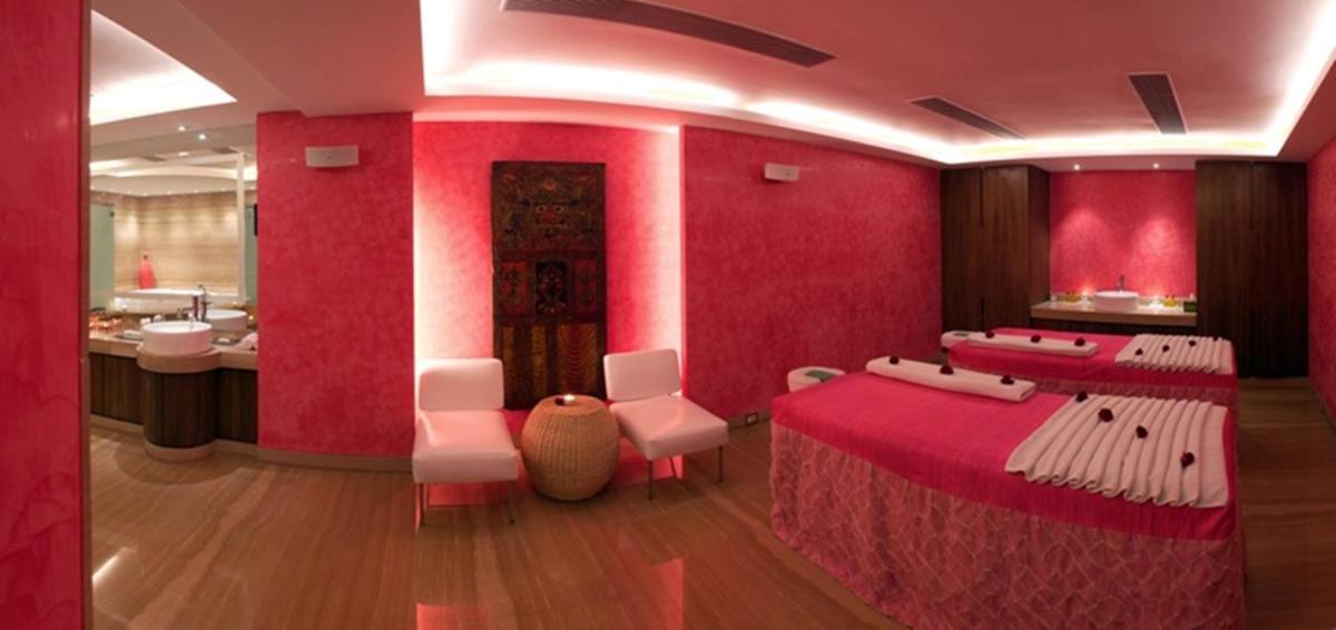 a room with red walls and white tables and chairs at The Park Kolkata in Kolkata